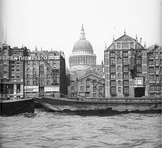 black and white photograph of old buildings on the water in front of a domed building