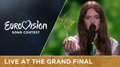 a woman singing into a microphone with a plant growing out of her hand and the words eurovision song contest