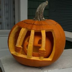 a pumpkin carved to look like a jail cell with a rat on it's head