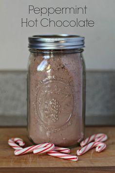 peppermint hot chocolate in a mason jar with candy canes on the side