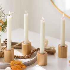 four candles are sitting on a tray with beads and leaves around it, along with other decorations