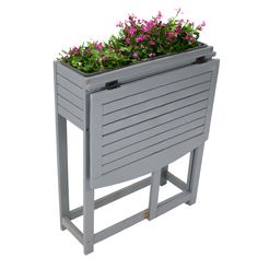 a grey planter with purple flowers in it on a white background, isolated from the side