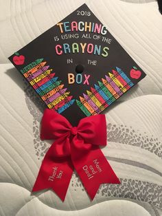 a graduation cap with the words teaching is using all of the crayons in the box