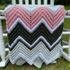 a crocheted pillow sitting on top of a white rocking chair