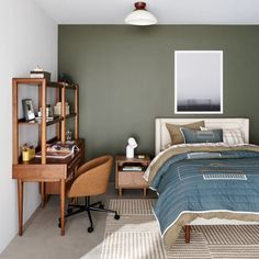 a bedroom with a bed, desk and chair next to a book shelf on the wall