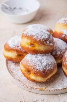 powdered sugar covered doughnuts on a plate