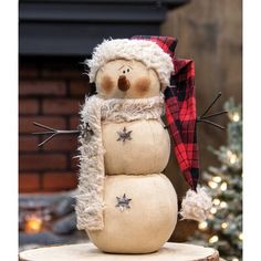 a snowman sitting on top of a tree stump