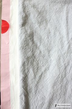 two pieces of fabric are laying next to each other on a table with red and pink accents