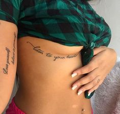 two women with tattoos on their stomachs and one has writing on the side of her body