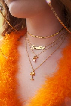 a close up of a woman wearing a necklace with nameplates on the chain