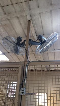 two snowboarders are hanging upside down from the ceiling in an enclosed area with metal bars