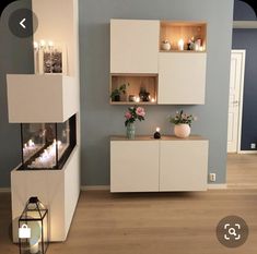 a living room filled with furniture and candles on top of the shelves next to each other