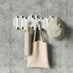 a tote bag hanging on the wall next to a hat and other items in front of it