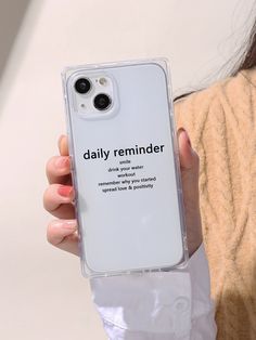 a woman holding up her phone case with the words daily reminder on it in black