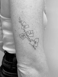 a black and white photo of a woman's arm with a flower tattoo on it