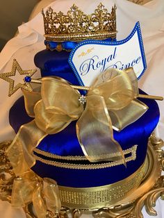 a blue and gold cake with a crown on top