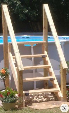 an above ground swimming pool with steps leading up to the bottom and flowers in pots below