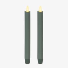 two green candles with yellow lights on them