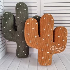 two cactus shaped cushions sitting next to each other