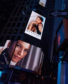 several billboards on the side of a building in new york city at night time