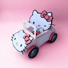 a hello kitty wooden car on a pink background