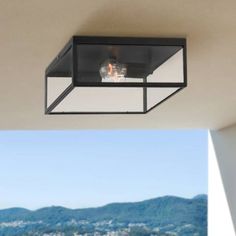 an outdoor ceiling light on the outside of a house with mountains in the background and blue sky