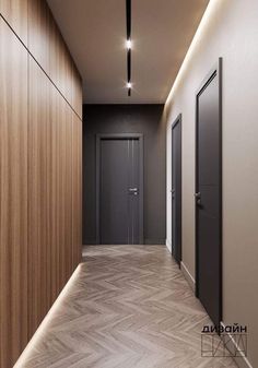 an empty hallway with wood paneling and black doors