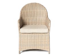 a wicker chair with a cushion on the back and seat padding, in front of a white background