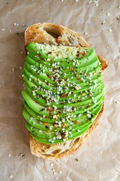 a piece of bread with green fruit and sprinkles on it