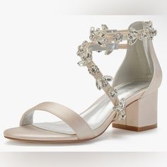 a woman's white high heeled sandal with crystal embellishments