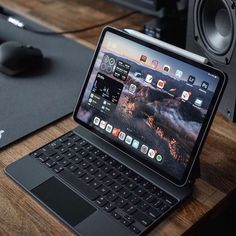 an open laptop computer sitting on top of a wooden desk next to a mouse and keyboard