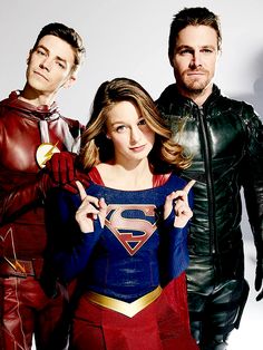 two men and a woman in costume posing for the camera with one man dressed as superman