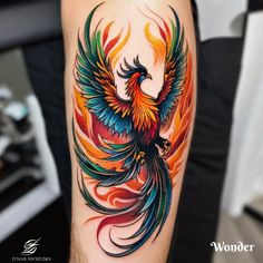 a colorful bird tattoo on the arm with flames in it's tail and wings