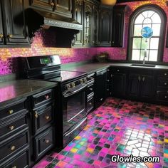 a kitchen with black cabinets and colorful tiles on the floor