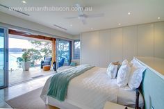 a bedroom with a large bed and sliding glass doors leading to an outside deck area