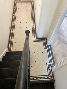 an image of a stair way going up to the top floor with black and white tiles on it