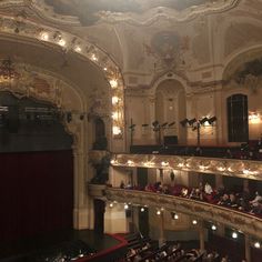 an auditorium filled with lots of people and lights