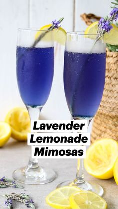 two glasses filled with blue liquid next to lemons and lavender sprigs on a table