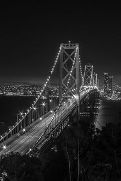 a black and white photo of the bay bridge in san francisco, california at night