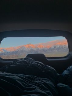 an airplane window with mountains in the background