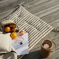 an open book and some oranges on a wooden table next to a cup of tea