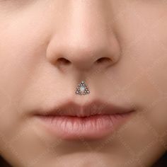 a woman's nose with a piercing in the shape of a tear on it