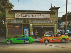 two cars parked in front of a market