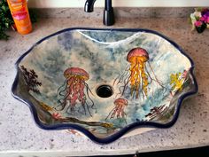 a bathroom sink decorated with jellyfish and sea creatures