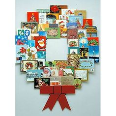 a christmas wreath made out of many different greeting cards with a red bow on the front