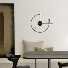 a clock mounted to the side of a wall next to a dining room table and chairs