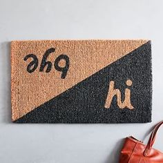 a door mat with the word pho on it next to a handbag and purse