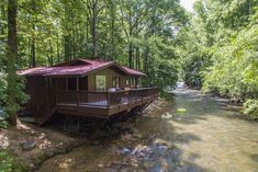 a small cabin sits on the bank of a river