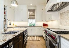 a large kitchen with white cabinets and marble counter tops on the counters, along with stainless steel appliances