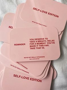 four pink self - love cards on a white sheet